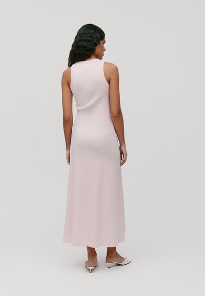 Mouwloze, figuuraccentuerende roze maxi-jurk met een gladde textuur, die onder de enkels reikt. De zoom is lichtjes uitlopend.