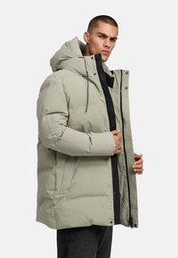 Hellgrüne Daunenjacke mit Kapuze, ausgestattet mit einem durchgehenden Reißverschluss und Druckknöpfen, Seitentaschen und einer glatten, gepolsterten Textur.