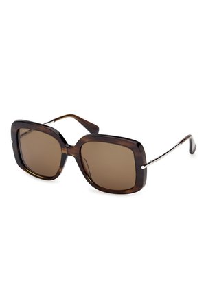 Przesadnie duże kwadratowe okulary przeciwsłoneczne w brązowym odcieniu, z ciemną plastikową oprawką w panterkę i cienkimi metalowymi zausznikami zakończonymi zakrzywionymi końcówkami.