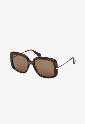 Gafas de sol cuadradas extragrandes con lentes teñidas en marrón, montura de plástico con diseño carey oscuro y finas varillas metálicas con puntas curvadas en las patillas.