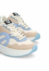 Sneaker beige e blu chiaro con tessuto texturizzato, suola in gomma tonda e accenti a contrasto. I lacci e il logo sulla linguetta sono visibili.