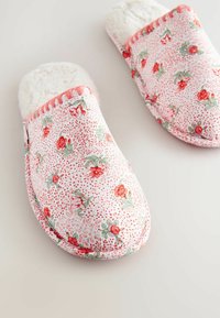 Ziedu raksta čības ar rozā fonu un sarkanām rozēm, mīksta balta odere un izšūtas akcenta detaļas ap apakšējo malu.