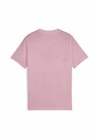 T-shirt en coton, couleur rose pastel, à manches courtes, col rond. Texture lisse sans motifs ni designs visibles.