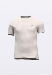 Κοντομάνικο T-shirt σε ανοιχτό μπεζ, κατασκευασμένο από μαλακό ύφασμα με στρογγυλή λαιμόκοψη και μικρό σκούρο λογότυπο στο αριστερό στήθος. Λείο υφή.