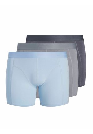 Trois paires de boxers pour hommes en bleu clair, gris et gris foncé, empilés avec détails sur l’avant et ceintures élastiques visibles.