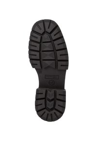 Suola di scarpa in gomma nera con motivi di battistrada profondi, superficie testurizzata e scanalature angolate per la trazione. Logo circolare al centro superiore.