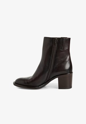 Bottine en cuir noir avec un bout rond, fermeture éclair latérale et finition texturée. Présente un talon empilé marron de 5 à 7 cm de hauteur.