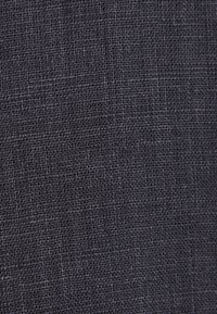 Tissu tissé gris foncé avec une texture serrée en forme de grille montrant des motifs fibreux détaillés et de légères variations de teintes.