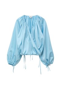 Blouse bleu clair à manches longues avec encolure froncée, devant croisé, coupe ample et liens à cordons aux poignets et à l’ourlet.