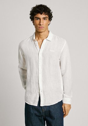 White linen long-sleeve shirt with a button-down collar, featuring a chest pocket and a straight hem, worn over blue denim jeans.