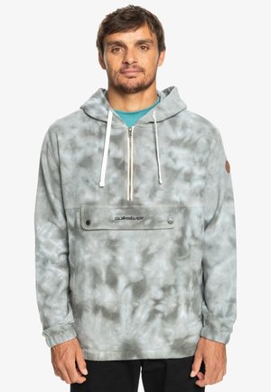 Grau melierter Kapuzenpullover im Tie-Dye-Muster. Mit einer Reißverschlusstasche vorne und einer Kordelzugkapuze. Hergestellt aus weichem, strukturiertem Fleece-Material.