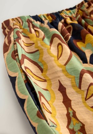 Bunt gemusterter Stoff mit geschwungenen Formen in Grün, Braun, Creme und Marineblau, verfügt über einen elastischen Bund und eine weiche Textur.