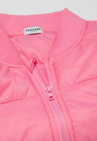 Růžová péřová bunda s žebrovaným límcem, předním zipem a lehkým materiálem. Tkanina je hladká a lesklá, bez viditelných vzorů.