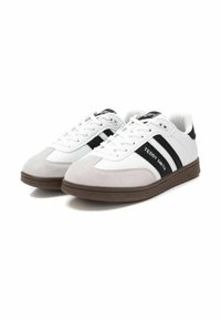 Zapatillas blancas con detalles en gamuza en rayas grises y negras. Presenta una suela de goma y cordones. Marca en el costado.