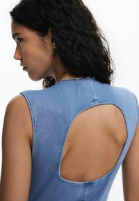 Ärmelloses Top aus strukturiertem blauen Stoff mit einem großen, offenen Rückendesign. Die Textur ist weich, mit einer figurbetonten Silhouette und rundem Ausschnitt.