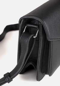 Borsa a mano in pelle nera con superficie testurizzata, dotata di una patta superiore, hardware color argento e una tracolla regolabile.