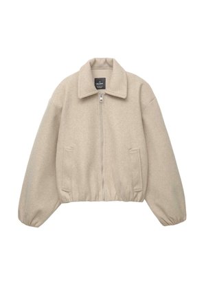 Beige cropped jack gemaakt van zachte stof, met een ritssluiting aan de voorkant, grote kraag en twee zijzakken met elastiek aan de onderkant en manchetten.