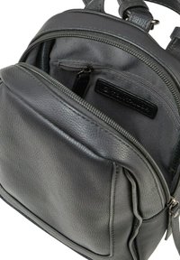 Sac à dos en cuir noir avec un extérieur texturé, un compartiment principal avec une fermeture éclair et une poche avant. L'intérieur est doublé de tissu foncé.
