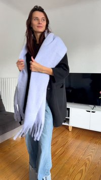 Svetlofialová šatka vyrobená z jemného materiálu, s třásňovými okrajmi. Nosená cez čierny oversized blazer a kombinovaná s poškodenými modrými džínsami.