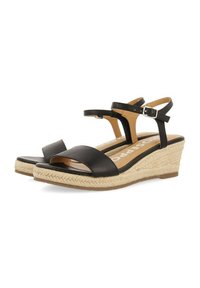 Sandalias de cuña negras de piel con suela de yute al estilo espadrille, que cuentan con una correa para el tobillo y diseño de punta abierta.