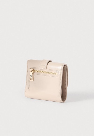 Μπεζ δερμάτινο πορτοφόλι με γυαλιστερό φινίρισμα, με μπροστινή τσέπη με φερμουάρ και κλείσιμο με αναδιπλούμενο καπάκι. Συμπαγές ορθογώνιο σχήμα.