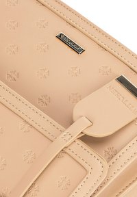 Beige leren tas met een geperst kruispatroon, goudkleurige hardware en een platte label. Heeft gestikte randen en een gladde textuur.
