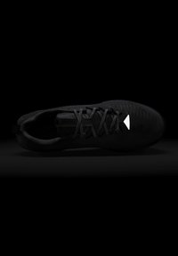 Black athletic shoe with mesh upper and laces, highlighted by a small white triangular logo near the toe.