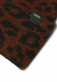 Czapka beanie w brązowy i czarny wzór lamparta, wykonana z teksturowanej dzianiny; posiada małą czarną metkę z napisem "JJXX" w złotym kolorze po boku.