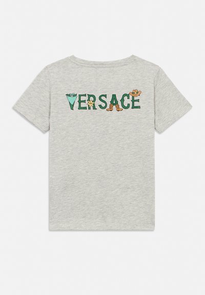 Ανοιχτό γκρι κοντομάνικο πουκάμισο με το κείμενο "VERSACE" πράσινο, διακοσμημένο με μπουκέτο λουλουδιών, αστέρι σερίφη, καουμπόικες μπότες και καπέλο.