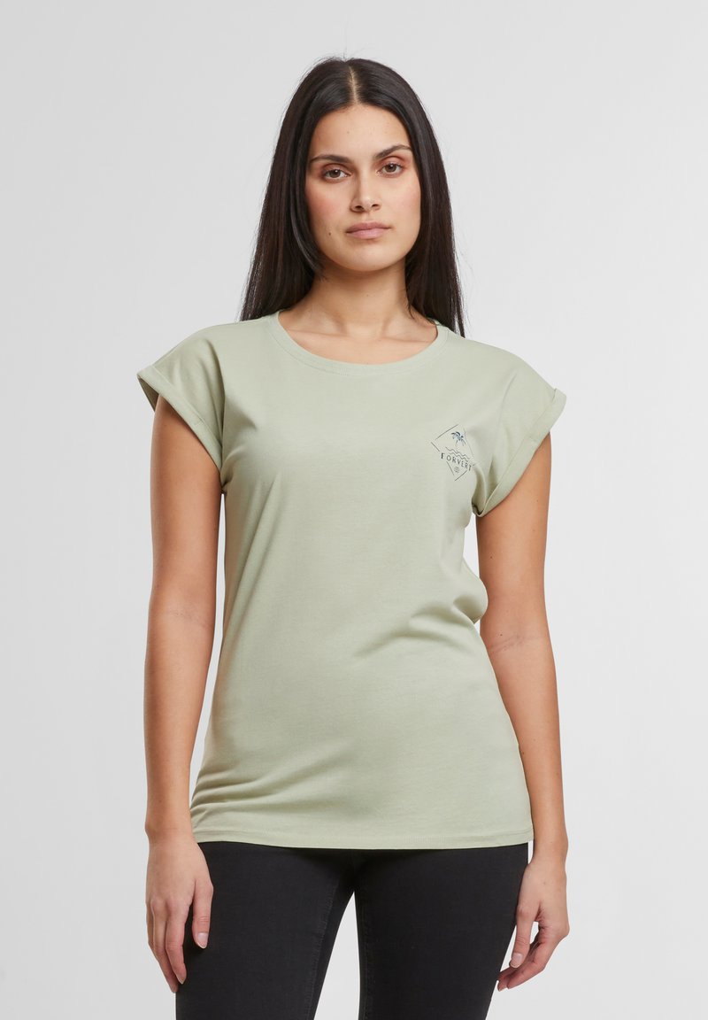 Hellgrünes Baumwoll-T-Shirt mit Rundhalsausschnitt, aufgerollten kurzen Ärmeln und einem kleinen grafischen Logo auf der linken Brust. Passt körpernah.