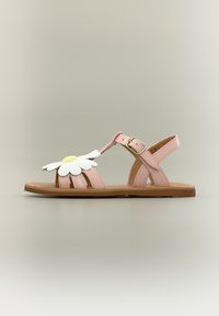 Sandale plate rose avec bride à la cheville et boucle, décorée d'une grande marguerite blanche et jaune sur les brides avant.