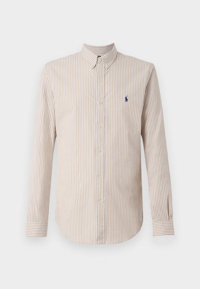 Camisa de mangas compridas às riscas em creme e castanho claro, com colarinho abotoado e um pequeno logótipo azul-marinho no peito.
