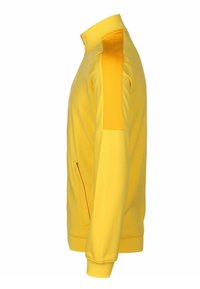 Veste de sport jaune avec un col montant, des poches latérales, des poignets côtelés et des accents texturés aux épaules. Fabriquée en tissu léger et lisse.
