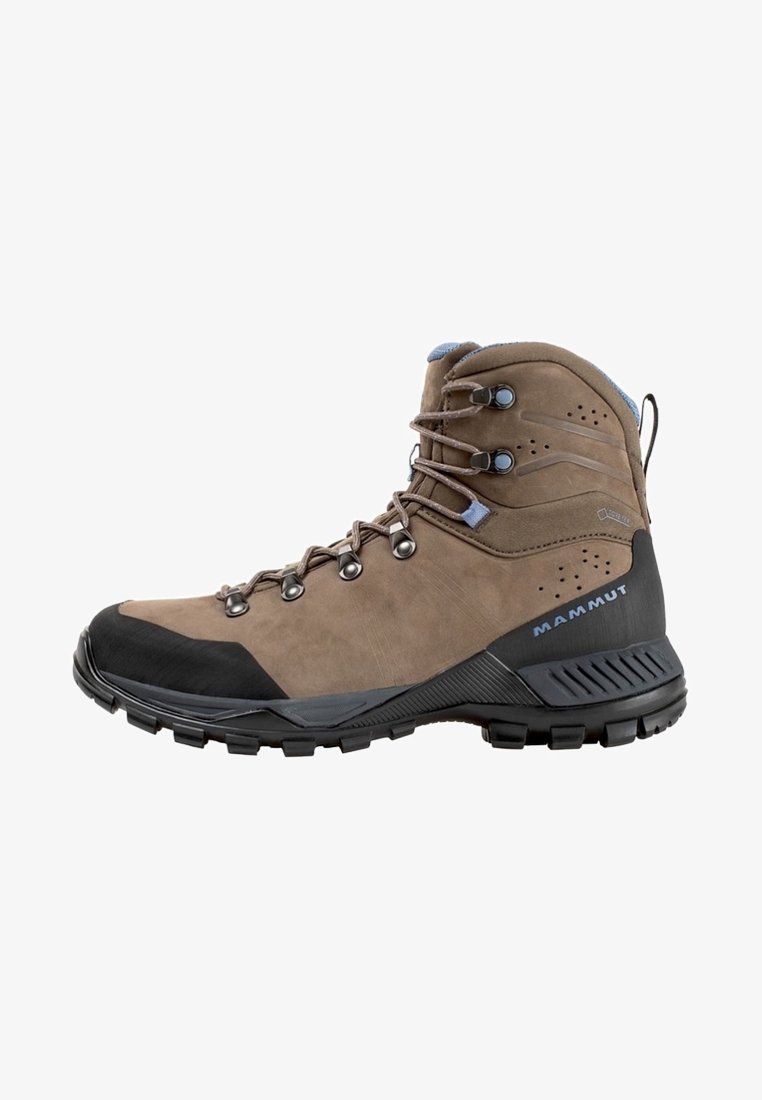 Scarpa da hiking marrone realizzata in suede e materiale sintetico, con una punta in gomma nera e accenti grigi. Presenta occhielli metallici e una suola testurizzata.