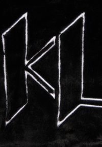 Svart tyg med en djärv, vit broderad "KL"-design. Texturen verkar mjuk och plyschig, med en slät yta och framträdande kontrast.