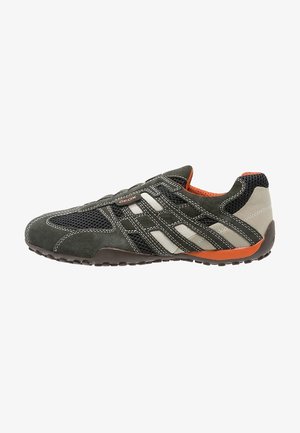 Zapatilla deportiva casual para hombre en gris oscuro con detalles en blanco y naranja, paneles de malla, superposiciones de ante y suela de goma con dibujo texturizado.