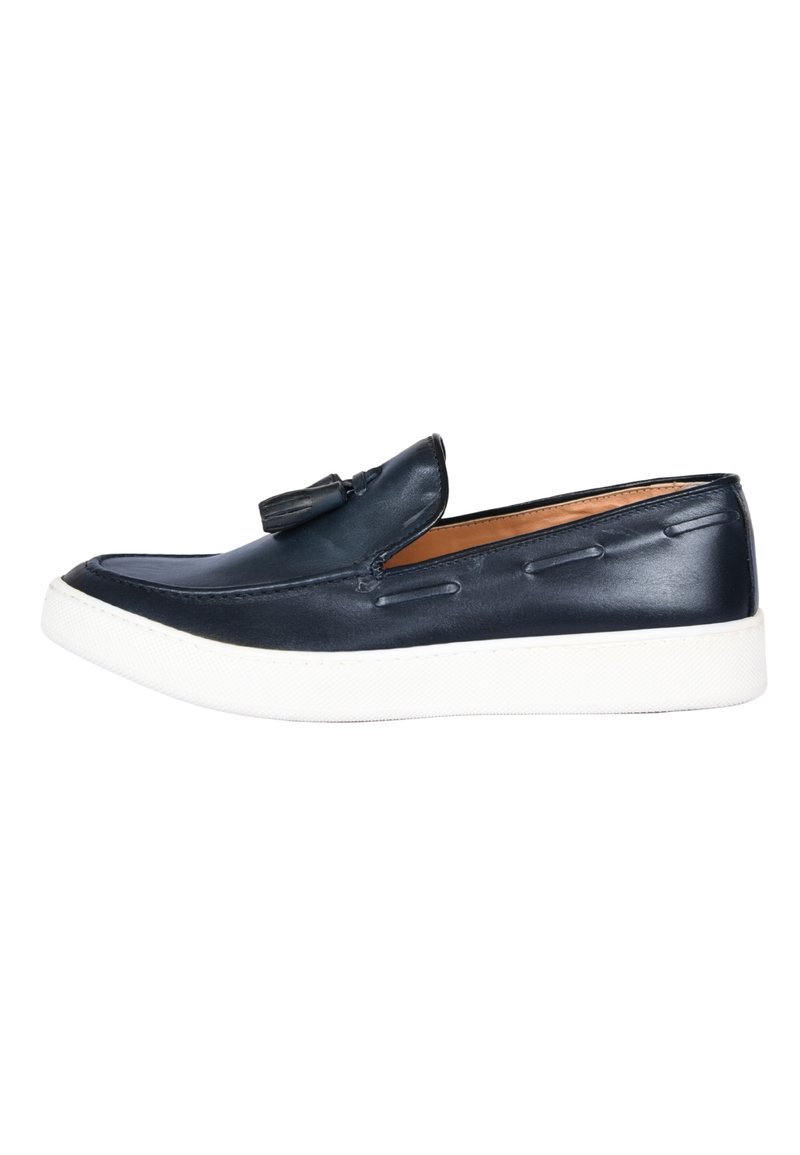 Scarpa slip-on in pelle blu con suola in gomma bianca, caratterizzata da dettagli di cucitura e una nappina decorativa sulla parte superiore.