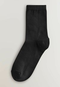 Chaussette crew noire avec bord-côtes, corps en maille lisse et talon et pointe renforcés, présentée sur un fond clair.