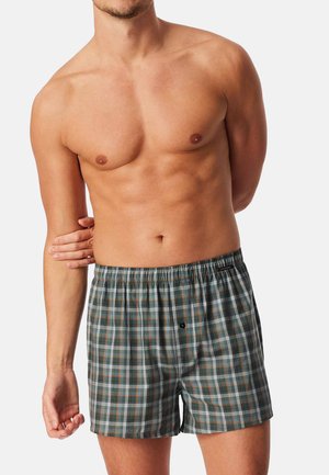 Boxershort in een geruit patroon met groene, oranje en witte kleuren. Elastische tailleband met een knoopdetail aan de voorkant.
