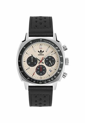 Montre chronographe avec un boîtier en acier inoxydable, un cadran beige, trois sous-cadrans noirs, des accents rouges et un bracelet en cuir perforé noir.