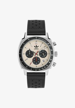 Chronograph watch with a stainless steel case, beige dial, three black sub-dials, red accents, and a black perforated leather strap.
