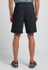 Pantaloni corti neri con vestibilità rilassata, realizzati in tessuto leggero, con una tasca sul retro e un semplice dettaglio di cucitura ai orli.