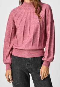 Růžový pletený svetr s žebrovanou texturou, vysokým límcem a balónovými rukávy. Obsahuje vertikální švy a přiléhavý žebrovaný lem.