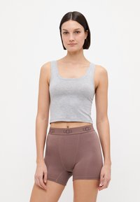 Débardeur gris court et slip en boîte marron avec ceinture de logo UGG. Le tissu semble doux, avec une texture lisse et un design épuré.