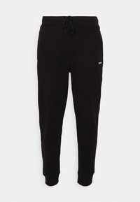 Zwarte joggingbroek van zacht materiaal, voorzien van een elastische tailleband met een trekkoord en geribde boorden. Een klein wit logo is zichtbaar aan de zijkant.