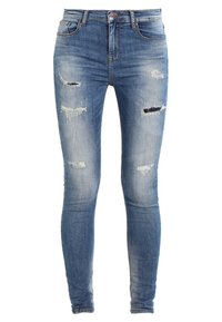 Tajta jeans i ljusblå denim. Har slitna detaljer och en blekt tvätt. Standard femfickorsdesign med knappstängning.