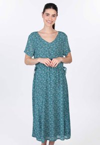 Kleid in Türkis mit floralem Muster, kurzen Ärmeln, V-Ausschnitt und Bindebändern in der Taille. Fließender, leichter Stoff mit einer knielangen Länge.