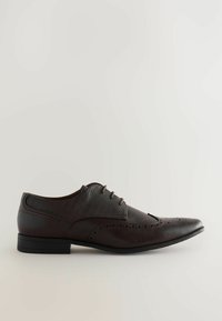 Chaussure habillée en cuir marron avec un bout pointu, des détails perforés et une tige en tissu texturé. Elle se distingue par des lacets marron et une semelle noire basse.