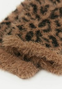 Faux-Fur-Decke in Braun mit einem schwarzen Leopardenmuster. Weiche, flauschige Textur mit fransigen Kanten. Eingerollte Kanten, die eine geschichtete Dicke zeigen.