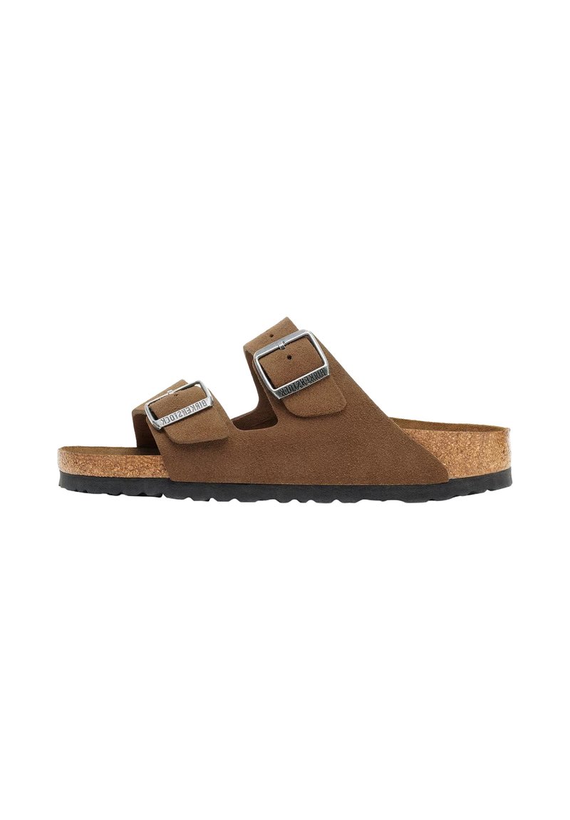 Bruine suède sandalen met twee verstelbare banden, zilveren gespen en een kurken voetbed, geplaatst op een gestructureerde zwarte rubberen zool.